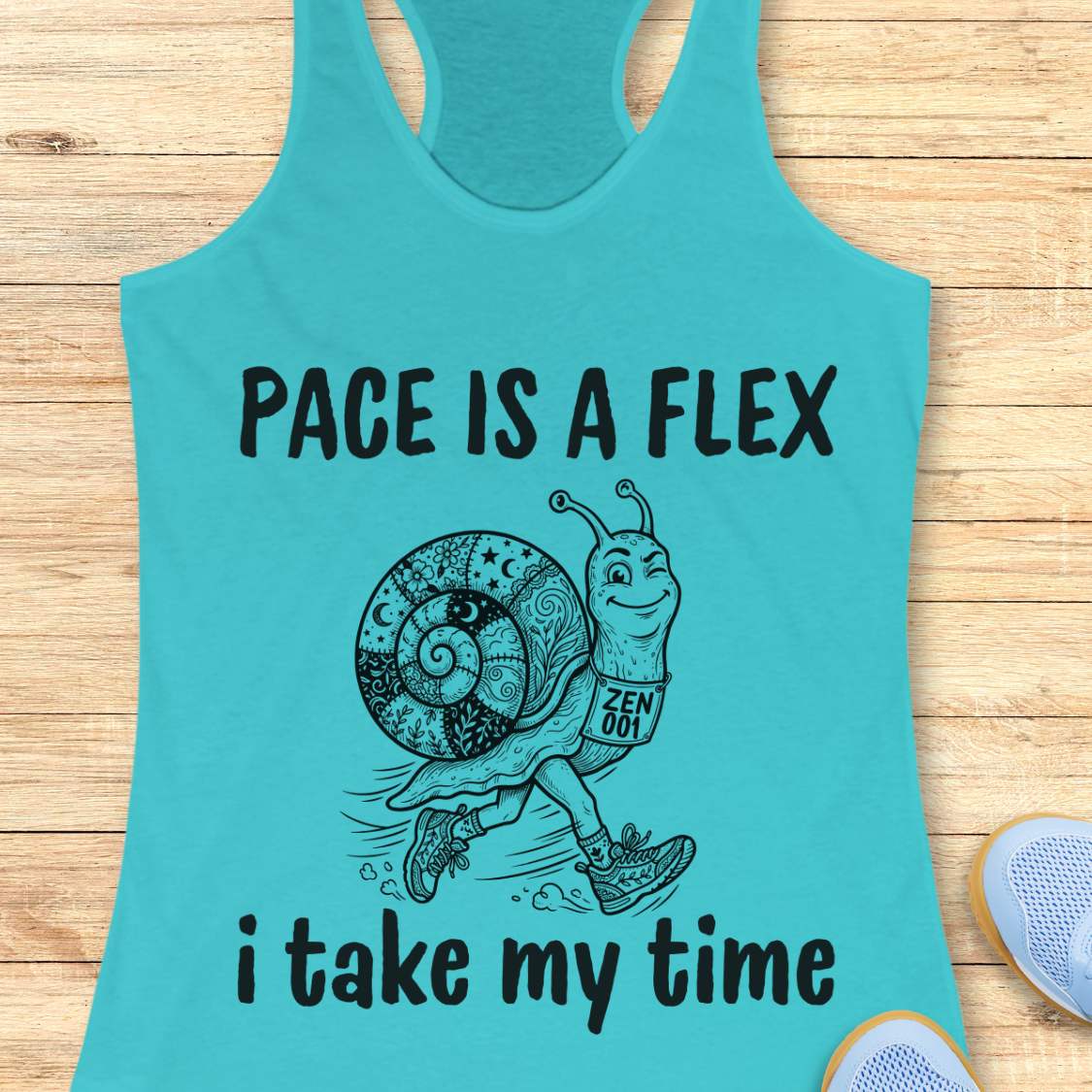 Turquoise tank top with a snail graphic and text pace is a flex , i take my time, on a wooden surface