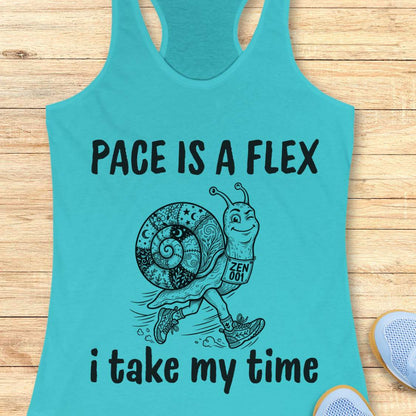 Turquoise tank top with a snail graphic and text pace is a flex , i take my time, on a wooden surface