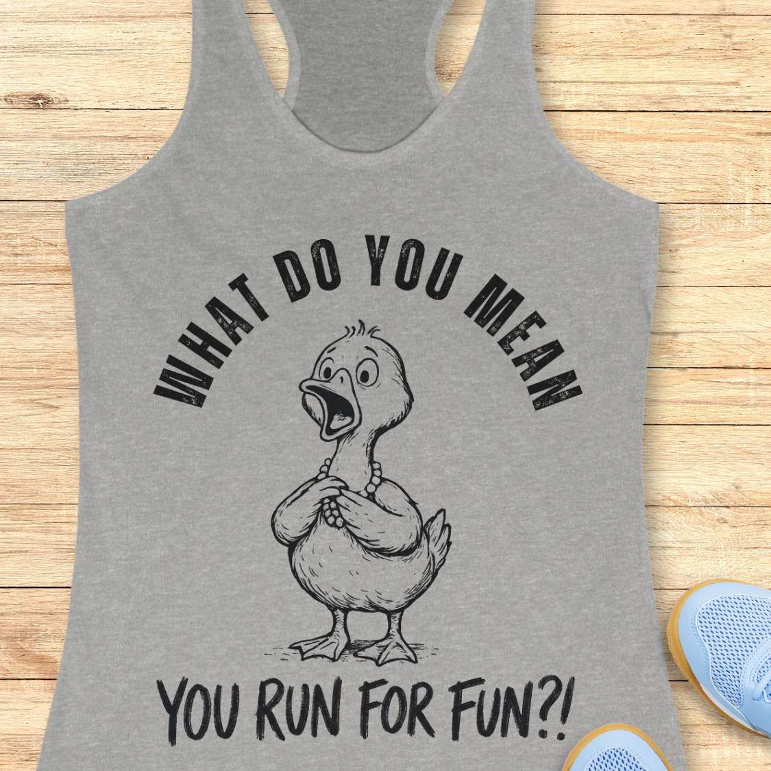 Gray tank top with a graphic of a duck and text what do you mean you run for fun, on a wooden surface