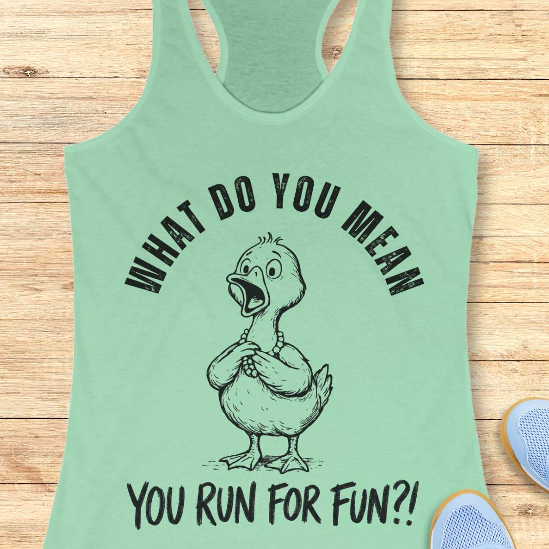 Mint green tank top with a graphic of a duck and text what do you mean you run for fun, on a wooden surface
