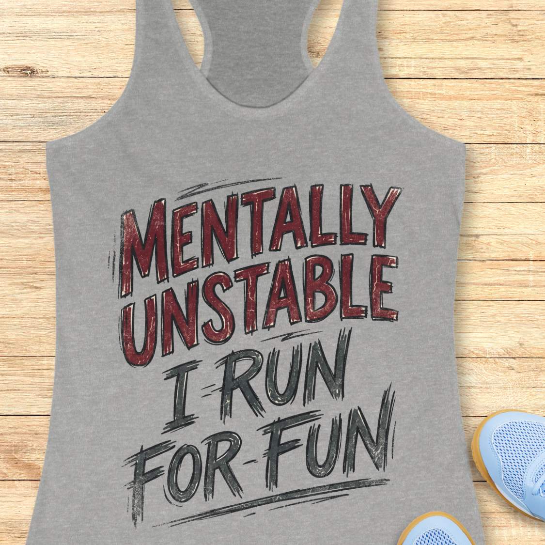 Gray tank top with 'Mentally Unstable I Run For Fun' text on a wooden surface