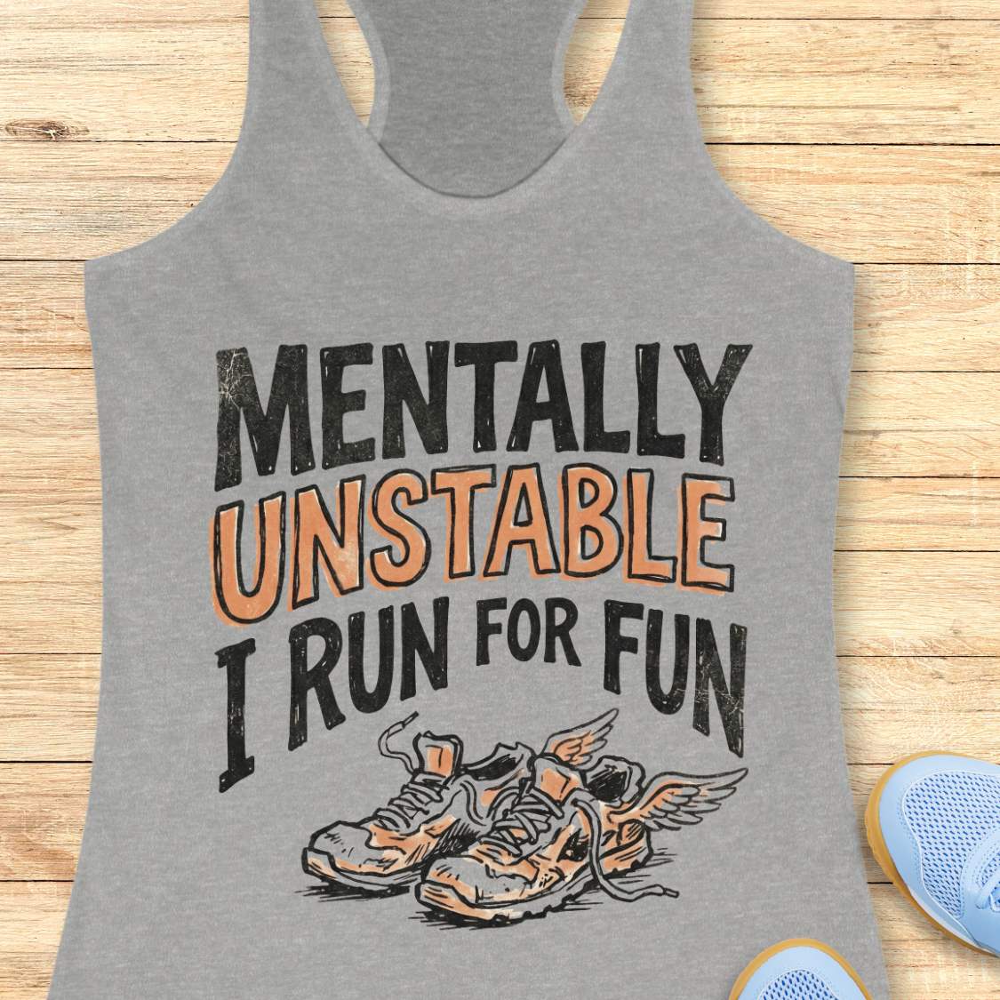 Gray tank top with 'Mentally Unstable I Run For Fun' text and shoe graphic on a wooden surface