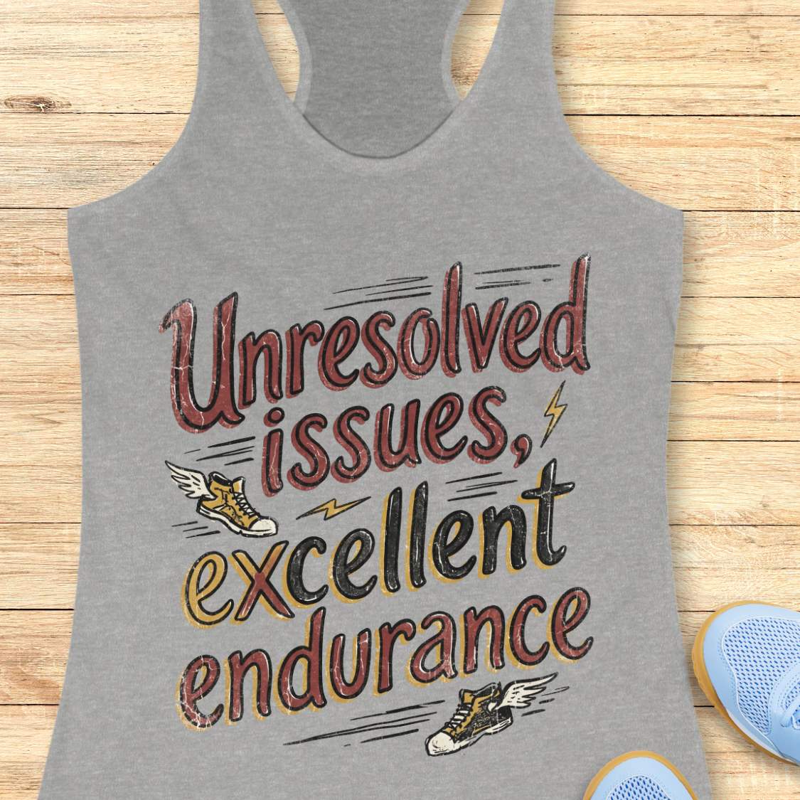 Gray tank top with humorous text 'Unresolved issues, excellent endurance' design on a wooden surface