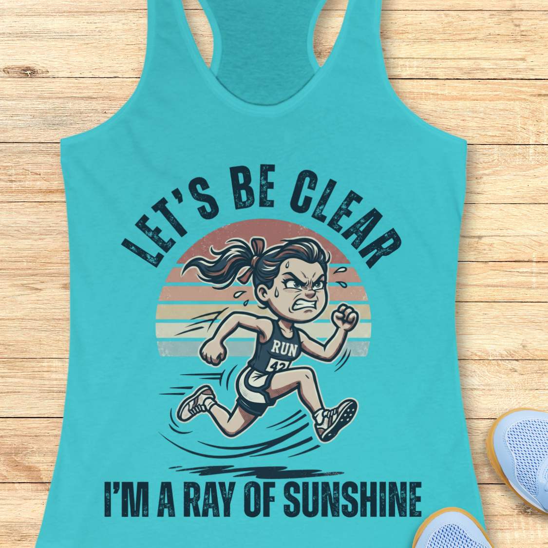 Turquoise tank top with a graphic of a running person and text let's be clear, I'm a ray of sunshine on a wooden surface