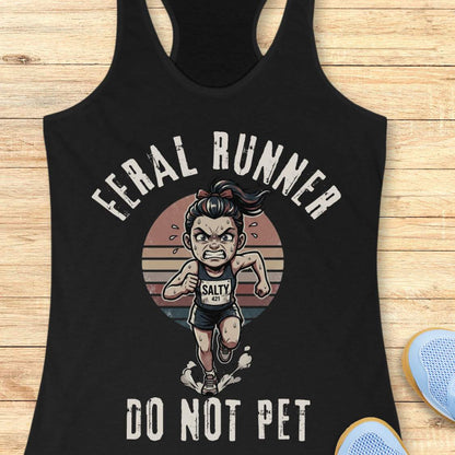 Black tank top with graphic design of a running person and text feral runner do not pet on a wooden surface