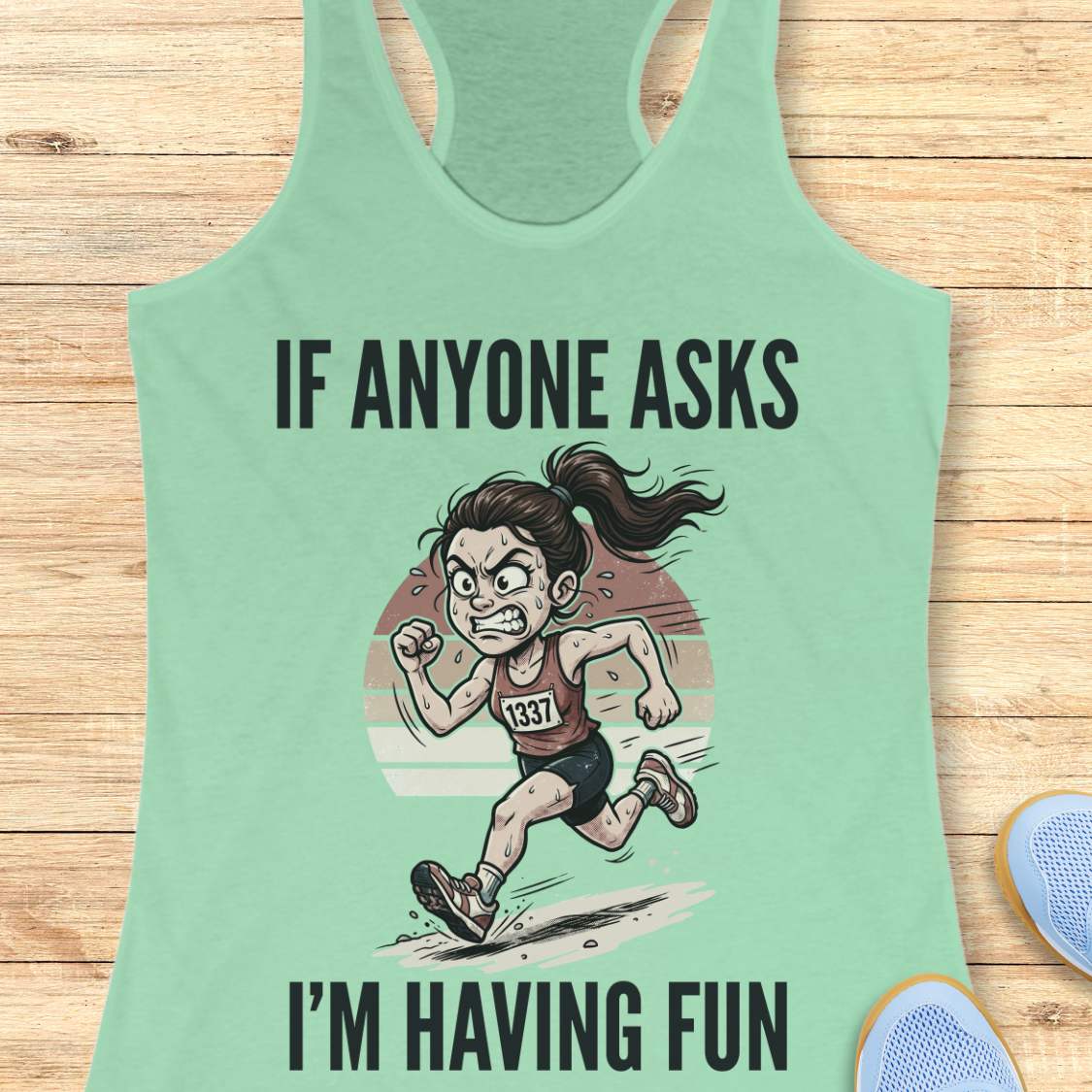 Mint green tank top with a graphic of a runner and text if anyone asks I'm having fun on a wooden surface