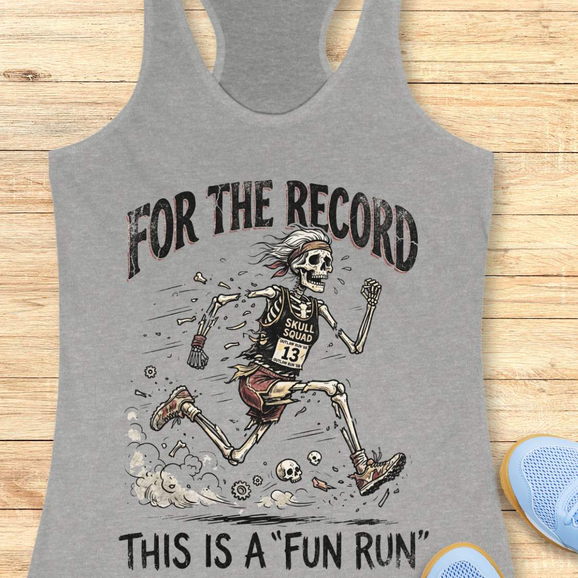 grey tank top with skeleton graphic and text 'For the Record, This is a Fun Run' on a wooden surface.