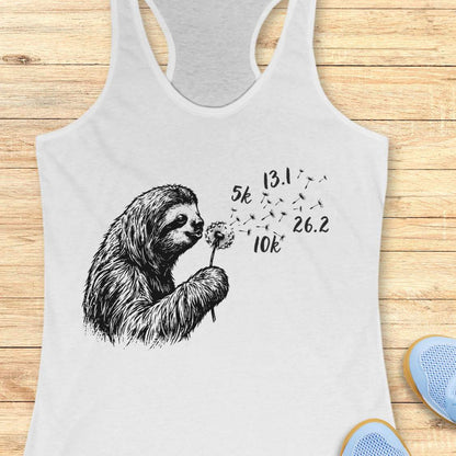 white tank top with a sloth holding a dandelion graphic on a wooden surface