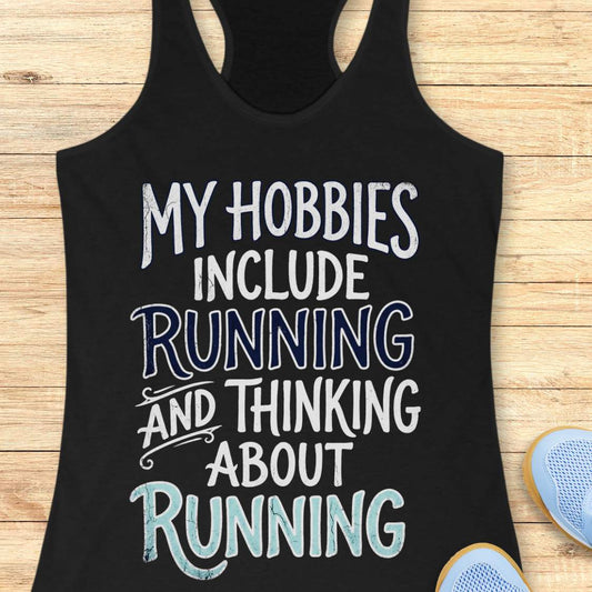 Black tank top with text 'My hobbies include running and thinking about running' on a wooden surface.