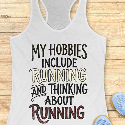 white tank top with text 'My hobbies include running and thinking about running' on a wooden surface.