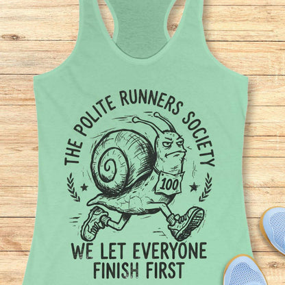 Light green tank top with a graphic of a snail and text 'The Polite Runners Society' on a wooden surface
