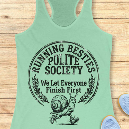 Mint green tank top with 'Running Besties Polite Society' graphic on a wooden surface