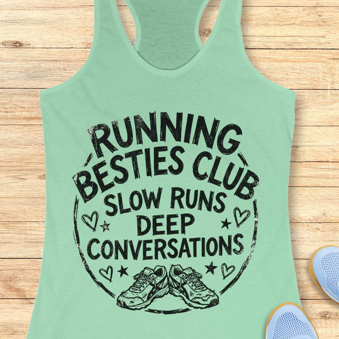 Mint green tank top with 'Running Besties Club' text on a wooden surface