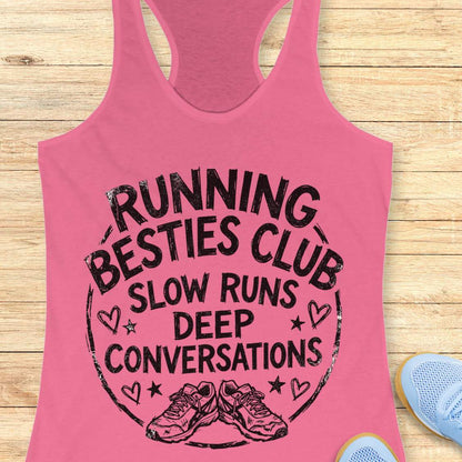 Pink tank top with 'Running Besties Club' text and graphic on a wooden surface.