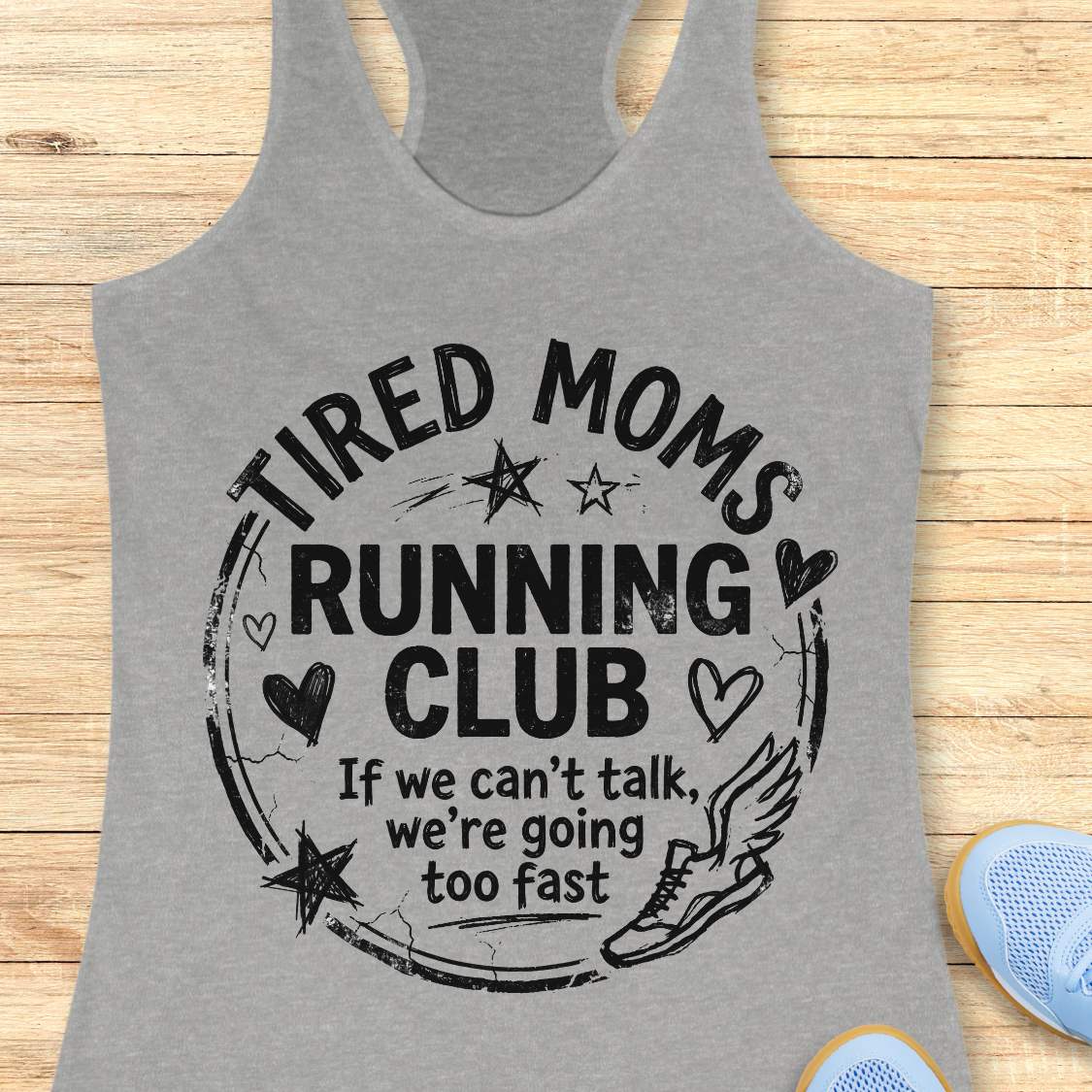 Gray tank top with 'Tired Moms Running Club' text on a wooden surface