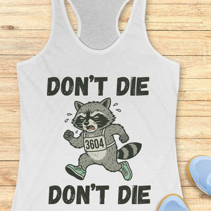 white tank top with raccoon graphic and text 'DON'T DIE' on a wooden surface