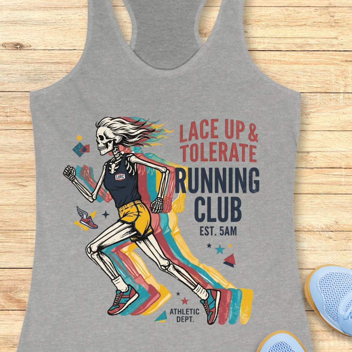 Gray tank top with skeleton design and 'Lace Up & Tolerate Running Club' text on a wooden surface