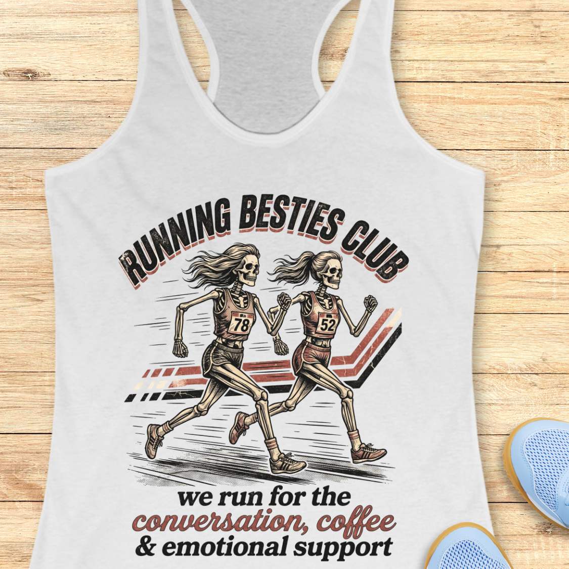 white Tank top with 'Running Besties Club' design featuring skeletons running, on a wooden surface.