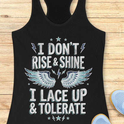 Black tank top with text I don't rise & shine, I lace up & tolerate,  and wings design on a wooden surface