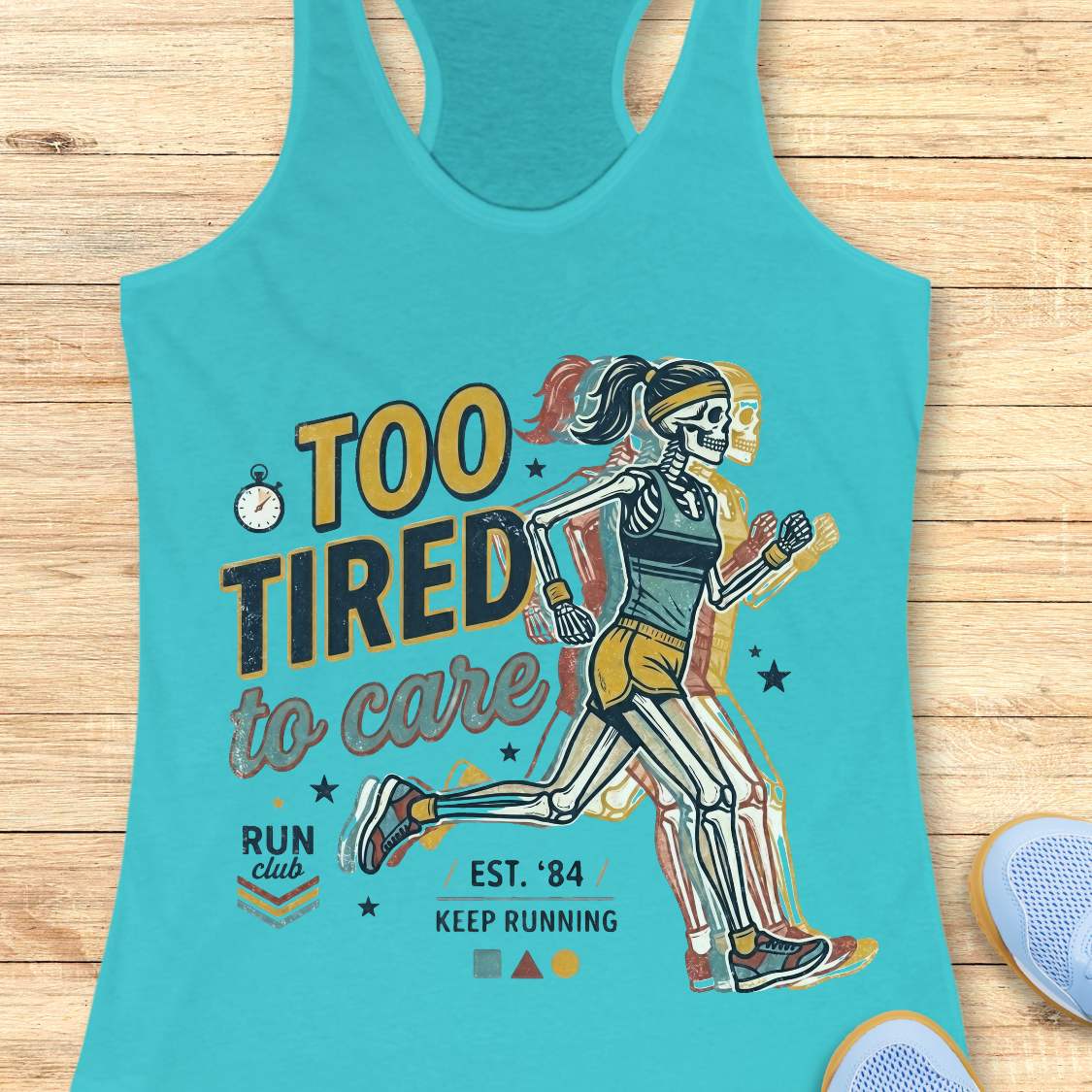 Turquoise tank top with skeleton runner graphic and text  too tired to care run club, on a wooden surface