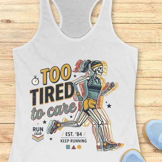 white tank top with a graphic design of a runner and text too tired to care run club, on a wooden surface