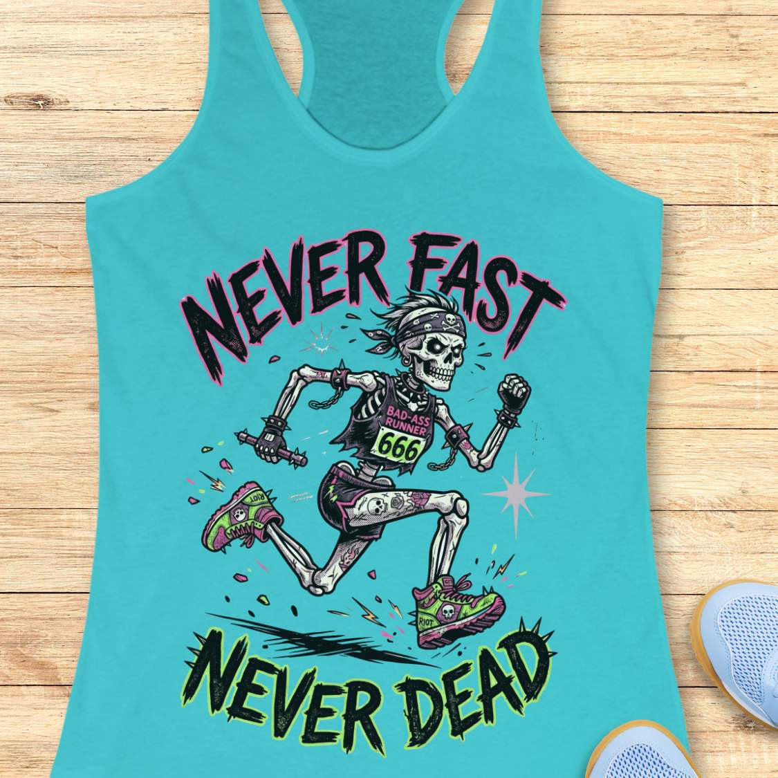 Turquoise tank top with skeleton graphic and 'Never Fast Never Dead' text on a wooden surface.