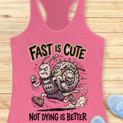 Pink tank top with graphic design and text fast is cute not dying is better, on a wooden surface