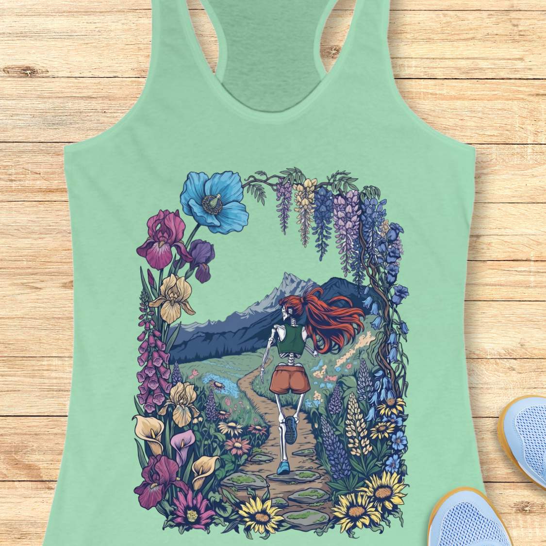 Green tank top with a colorful graphic of a person walking through flowers on a wooden surface.