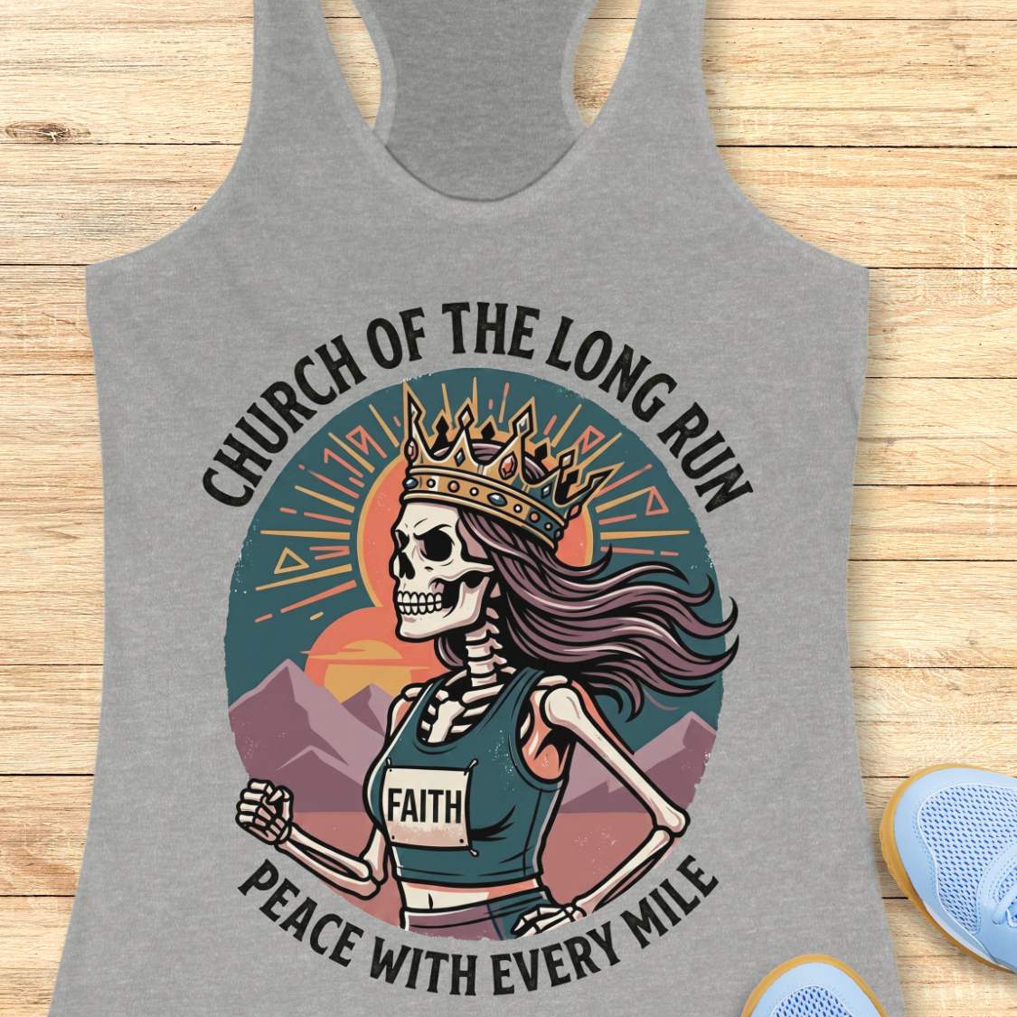 Gray tank top with skeleton design and text Church of the long run, peace with every mile, on a wooden surface