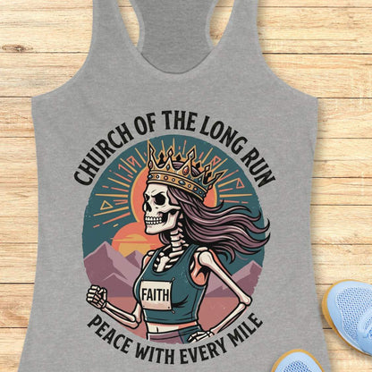 Gray tank top with skeleton design and text Church of the long run, peace with every mile, on a wooden surface