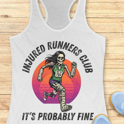 white tank top with skeleton runner graphic and text injured runners club, it's probably fine, on a wooden surface