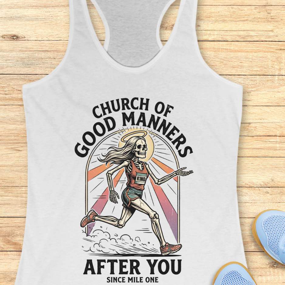 White tank top with skeleton design and text 'Church of Good Manners After You Since Mile One' on a wooden surface.