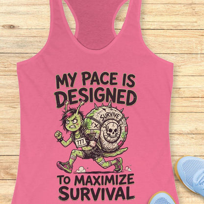Pink tank top with graphic design and text my pace is designed to maximize survival, on a wooden surface