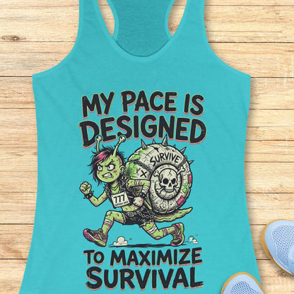 Turquoise tank top with graphic design and text my pace is designed to maximize survival, on a wooden surface