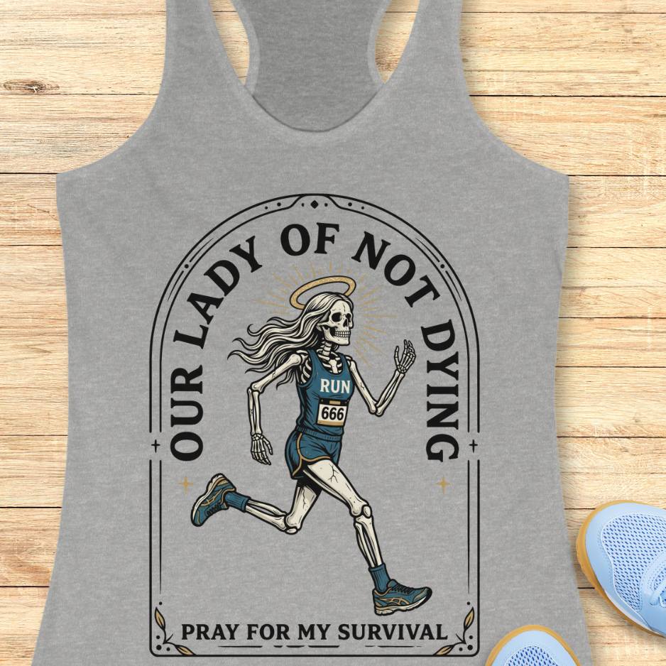 Gray tank top with skeleton runner design and text Our lady of noy dying, pray for my survival, on a wooden surface