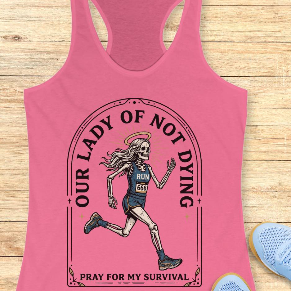 Pink tank top with skeleton runner graphic and text Our lady of noy dying, pray for my survival,  on a wooden surface