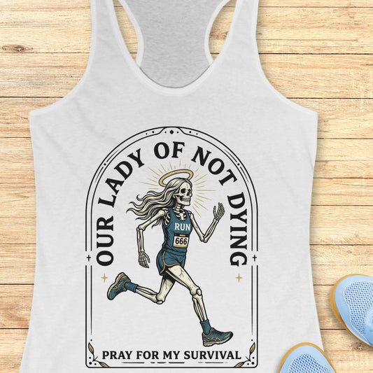 white tank top with skeleton runner design and text Our lady of noy dying, pray for my survival, on a wooden surface