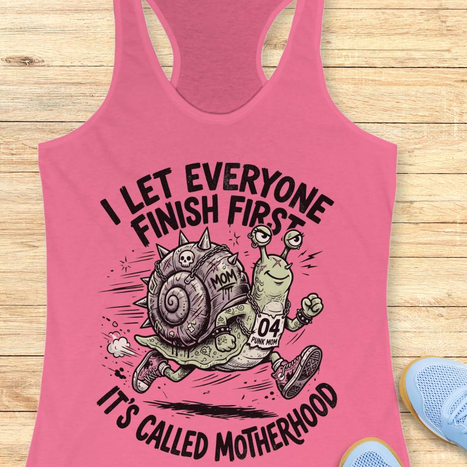 Pink tank top with a humorous snail graphic and text  I let everyone finish first, It's called motherhood, on a wooden surface