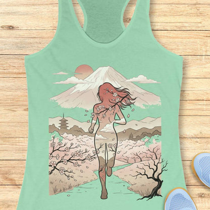 Mint green tank top with a graphic design of a woman, cherry blossoms, and Mount Fuji on a wooden surface.