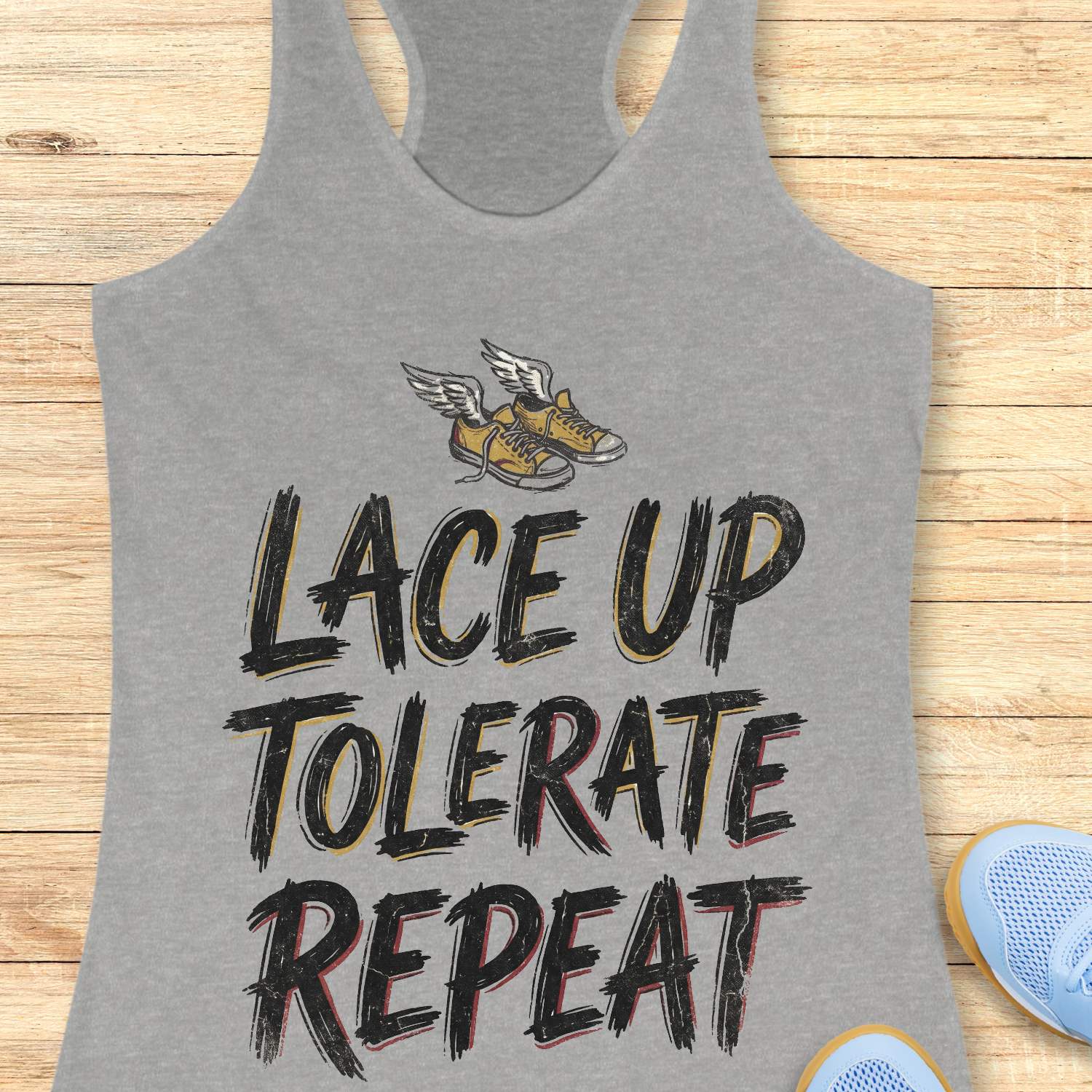 Gray tank top with 'Lace Up Tolerate Repeat' text and shoe graphic on a wooden surface