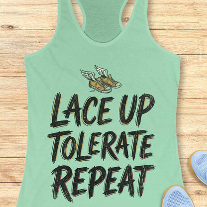 Light green tank top with text 'Lace Up Tolerate Repeat' on a wooden surface.