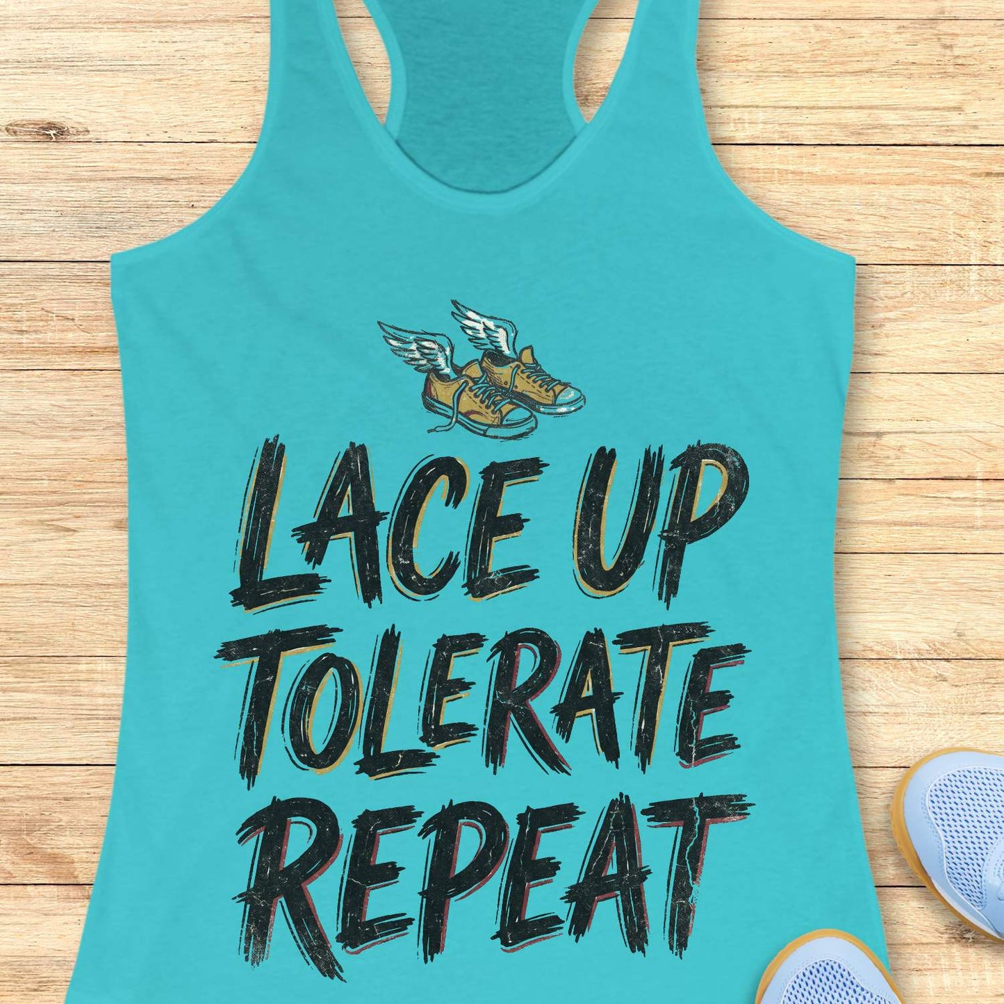 Turquoise tank top with 'Lace Up Tolerate Repeat' text and sneakers on a wooden surface