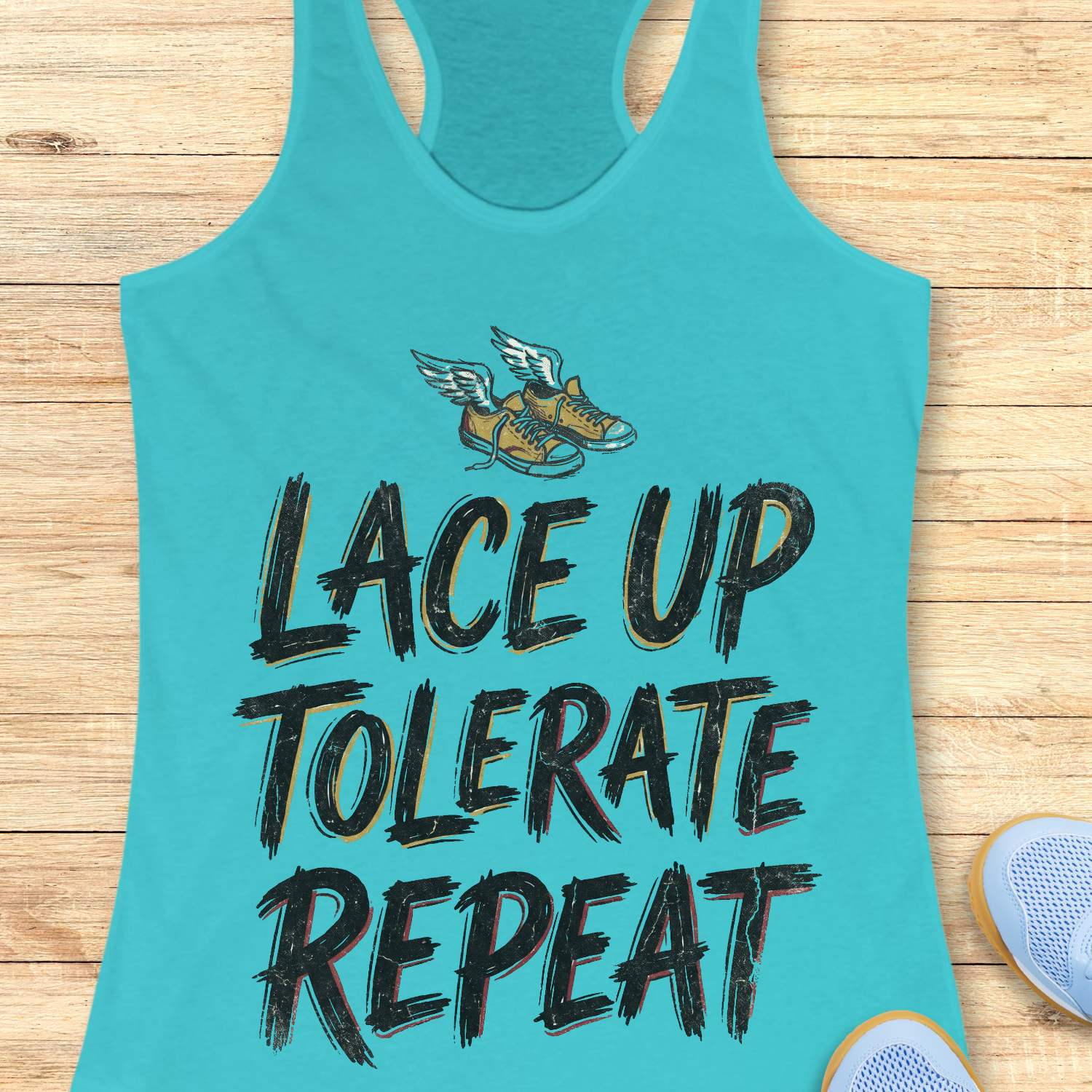 Turquoise tank top with 'Lace Up Tolerate Repeat' text and sneakers on a wooden surface
