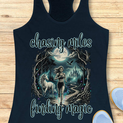 Navy tank top with a graphic of a woman running with a unicorn and text 'chasing miles finding magic' on a wooden surface.
