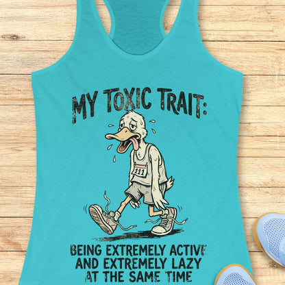 Turquoise tank top with cartoon character and humorous text ' my toxic trait - being extremely active and extremely lazy at the same time',  on a wooden surface