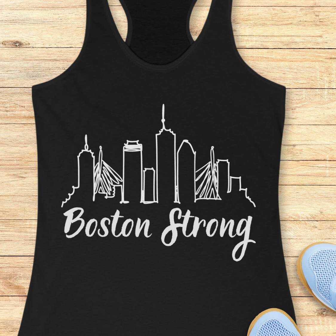 Black tank top with white 'Boston Strong' skyline design on a wooden surface