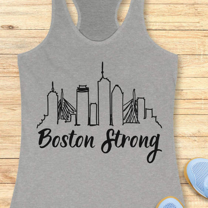 Gray tank top with 'Boston Strong' and city skyline design on a wooden surface