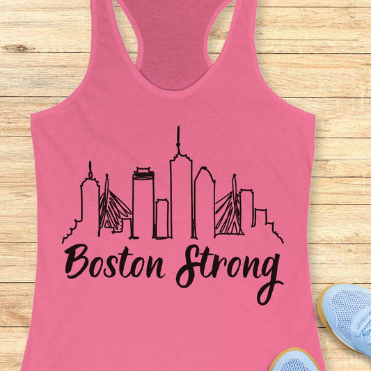 Pink tank top with 'Boston Strong' design on a wooden surface