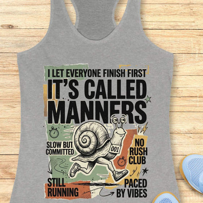 Gray tank top with humorous graphic and text on a wooden surface