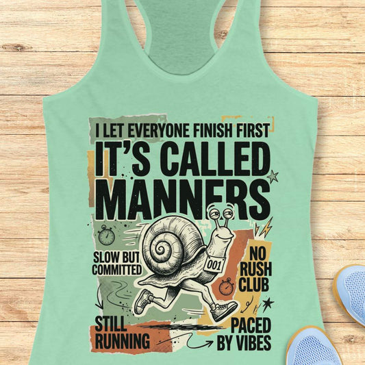 Mint green tank top with humorous graphic and text on a wooden surface